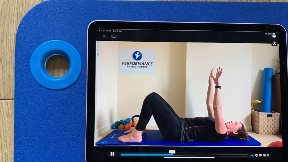 Image of Performance Physiotherapy demonstration on a tablet on a pilates mat